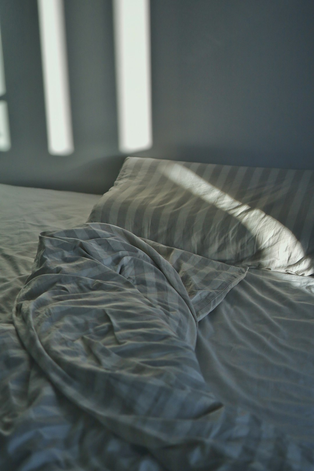 striped-blanket-and-pillow-on-bed-vcfgmpa-km0
